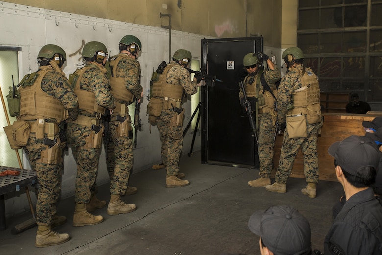 U.S. Marines with the Special Reaction Team (SRT) for Marine Corps Air Station Iwakuni (MCAS), display breaching techniques to members of the Hiroshima and Yamaguchi Prefectural Police Headquarters at MCAS Iwakuni, Japan, March 28, 2017. Members with the Hiroshima and Yamaguchi Prefectural Police Headquarters traveled to the air station to observe SRT conduct high-risk training scenarios. The training ranged from room-clearing, breaching, communication and non-lethal take-down techniques. (U.S. Marine Corps photo by Lance Cpl. Joseph Abrego)