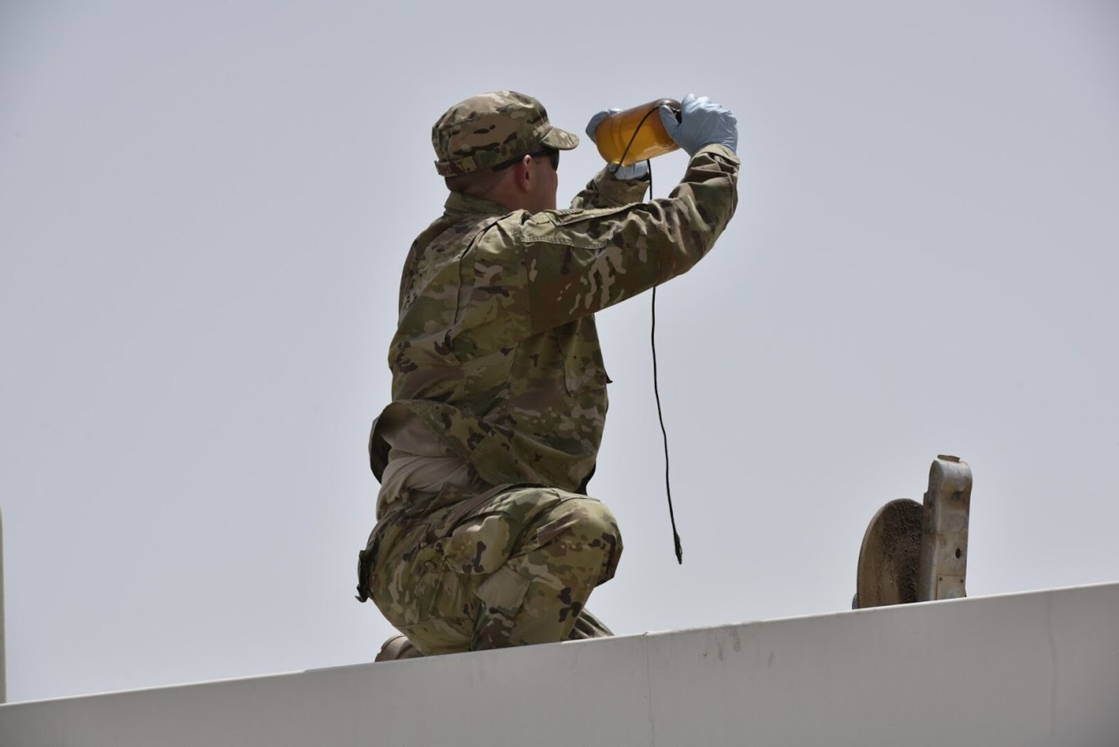Staff Sgt. Samuel Bonhorst, 407th Expeditionary Logistic Readiness Squadron petroleum, oil and lubricants flight fuels laboratory NCO in charge, inspects a sample of fuel before receiving a shipment May 10, 2017, in Southwest Asia. Fuel technicians maintain all POL substances, from diesel and gasoline to jet fuel and liquid oxygen. These materials play a vital role in delivering airpower to the fight against ISIS. The team here at the 407th Air Expeditionary Group supplies U.S. Marine Corps and coalition aircraft. (U.S. Air Force photo by Senior Airman Ramon A. Adelan)