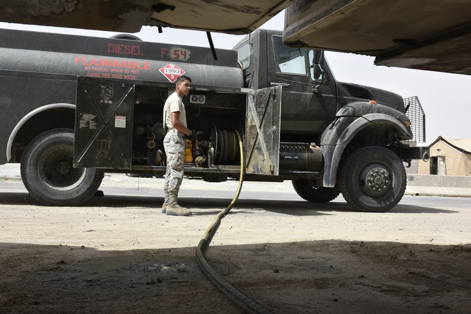 Senior Airman Adrian Alegria-Vasquez, 407th Expeditionary Logistic Readiness Squadron petroleum, oil and lubricants flight fuel distribution operator, monitors a customer pumping diesel May 10, 2017, in Southwest Asia. Fuel technicians maintain all POL substances, from diesel and gasoline to jet fuel and liquid oxygen. These materials play a vital role in delivering airpower to the fight against the ISIS. The team here at the 407th Air Expeditionary Group supplies U.S. Marine Corps, Italian and Polish air forces. (U.S. Air Force photo by Senior Airman Ramon A. Adelan)