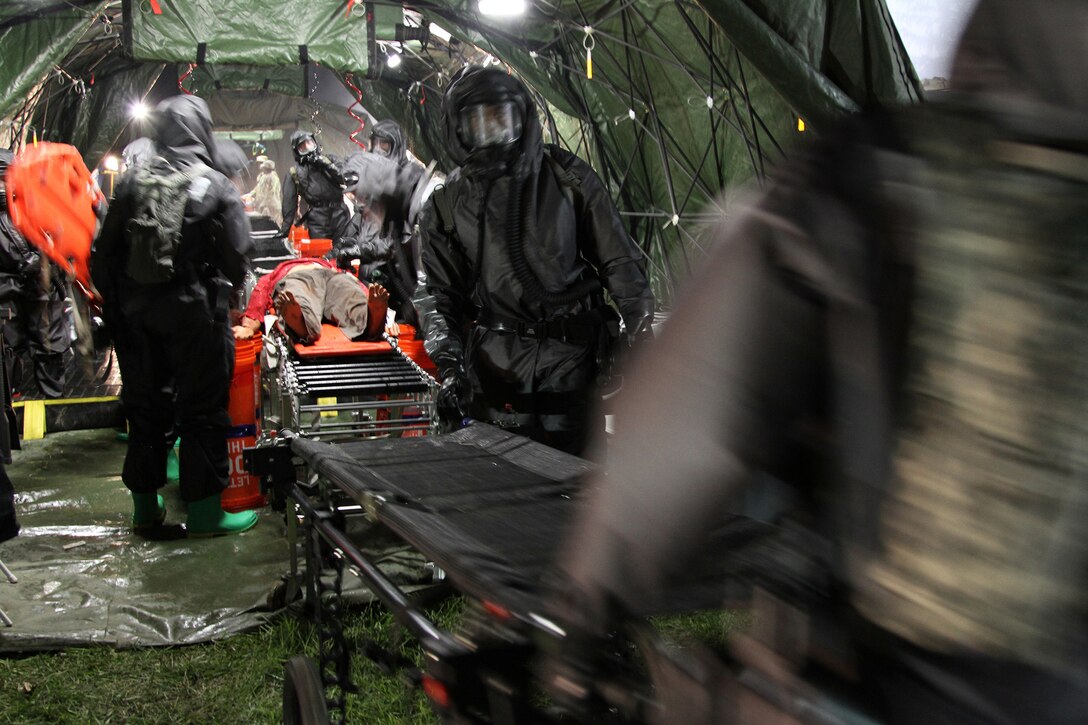 U.S. Army Reserve Soldiers from Madison, Wisconsin, based 409th Area Support Medical Company and 414th Chemical Company based in Orangeburg, South Carolina, work together to complete a mass casualty decontamination exercise May 8, 2017 at Muscatatuck Urban Training Center, Indiana. Nearly 4,100 Soldiers from across the country are participating in Guardian Response 17, a multi-component training exercise to validate U.S. Army units' ability to support the Defense Support of Civil Authorities (DSCA) in the event of a Chemical, Biological, Radiological, and Nuclear (CBRN) catastrophe. (U.S. Army Reserve photo by Sgt. Crystal Milton)