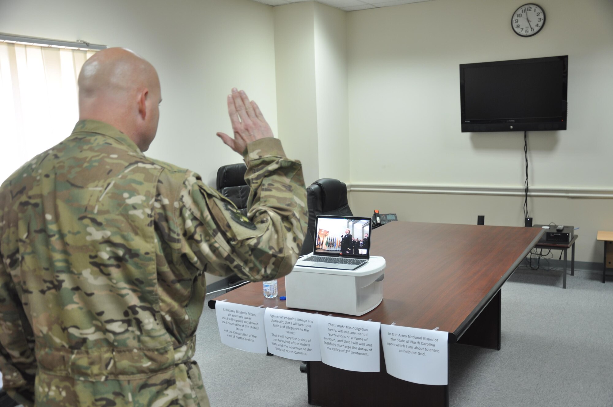 Maj. Bret Peters, the 737th Expeditionary Airlift Squadron assistant director of operations stands at attention as the Star Spangled Banner plays at his daughter’s commissioning ceremony at the University of North Carolina, Friday, May 12, 2017. Peters, a deployed member of the 386th Air Expeditionary Wing, commissioned his daughter via livestream.