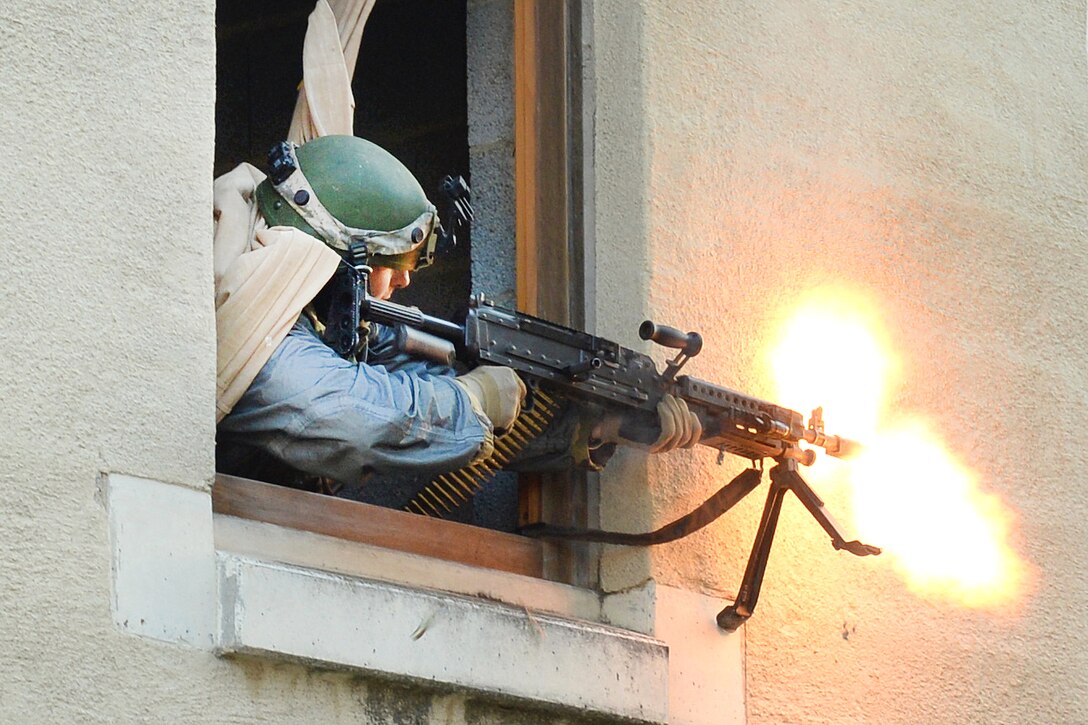 A soldier fires his machine gun from an open window during a field training exercise as part of Saber Junction 17 at the Joint Multinational Readiness Center, Hohenfels, Germany, May 15, 2017. Army photo by Staff Sgt. Richard Frost