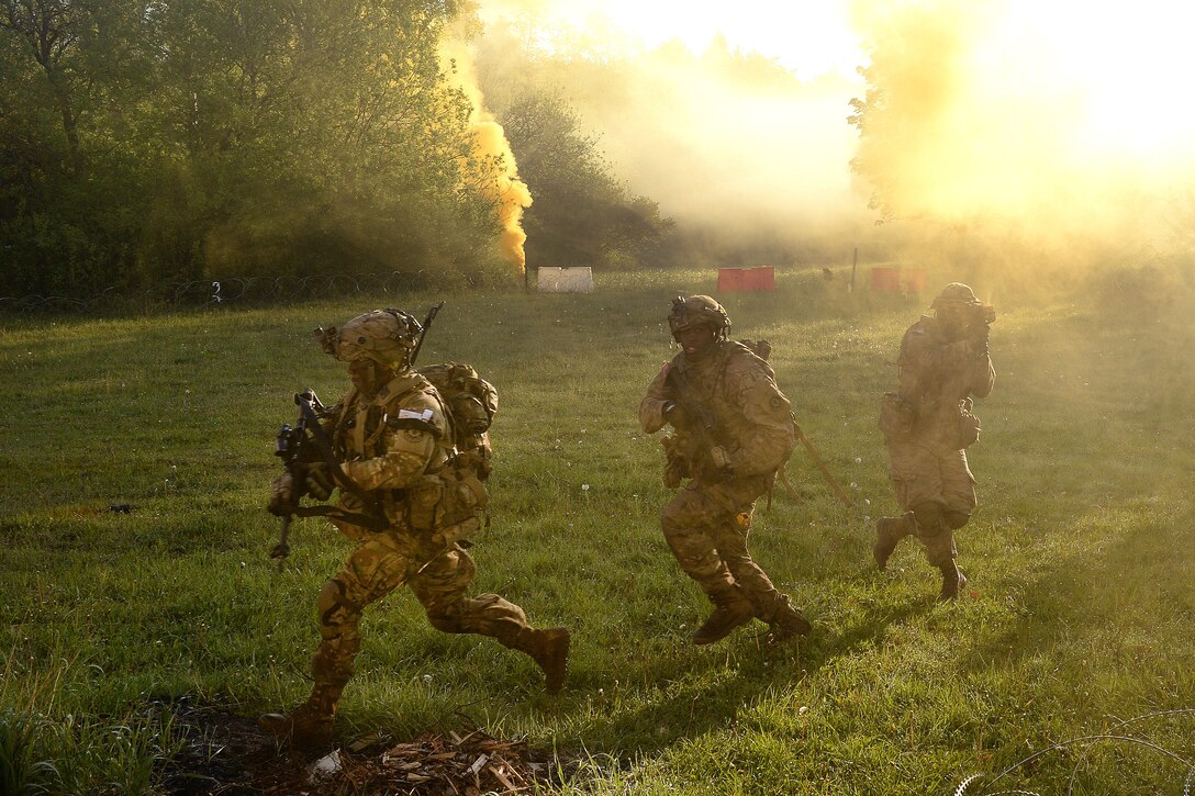 Soldiers rush through a field behind a small mock town during a field training exercise as part of Saber Junction 17 at the Joint Multinational Readiness Center, Hohenfels, Germany, May 15, 2017. Army photo by Staff Sgt. Richard Frost
