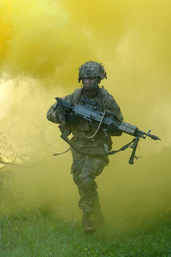 A soldier sprints with his M240 automatic weapon through the cover of smoke to his next objective during a field training exercise as part of Saber Junction 17 at the Joint Multinational Readiness Center, Hohenfels, Germany, May 15, 2017. Army photo by Staff Sgt. Richard Frost