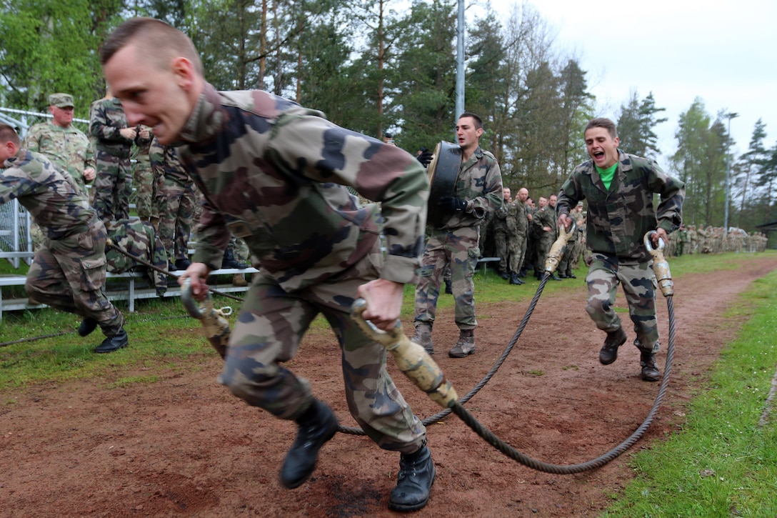 French soldiers compete against other nations in a relay race with tank-related objects while U.S. soldiers cheer them on in Grafenwoehr, Germany, May 12, 2017. Army photo by Staff Sgt. Kathleen V. Polanco