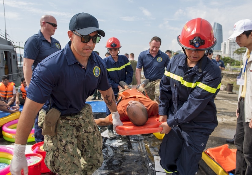 Navy Petty Officer 2nd Class Gustavo Llerenas, a hospital corpsman, front left, British Army Capt. Paul Bristow, back right, and Vietnamese emergency responders carry a simulated casualty to receive medical care while participating in a search and rescue and oil spill response field training exercise during Pacific Partnership 2017 in Danang, Vietnam, May 13, 2017. Pacific Partnership is the largest annual multilateral humanitarian assistance and disaster relief preparedness mission conducted in the Indo-Asia-Pacific region and aims to enhance regional coordination in areas such as medical readiness and preparedness for manmade and natural disasters. Navy photo by Petty Officer 2nd Class Joshua Fulton