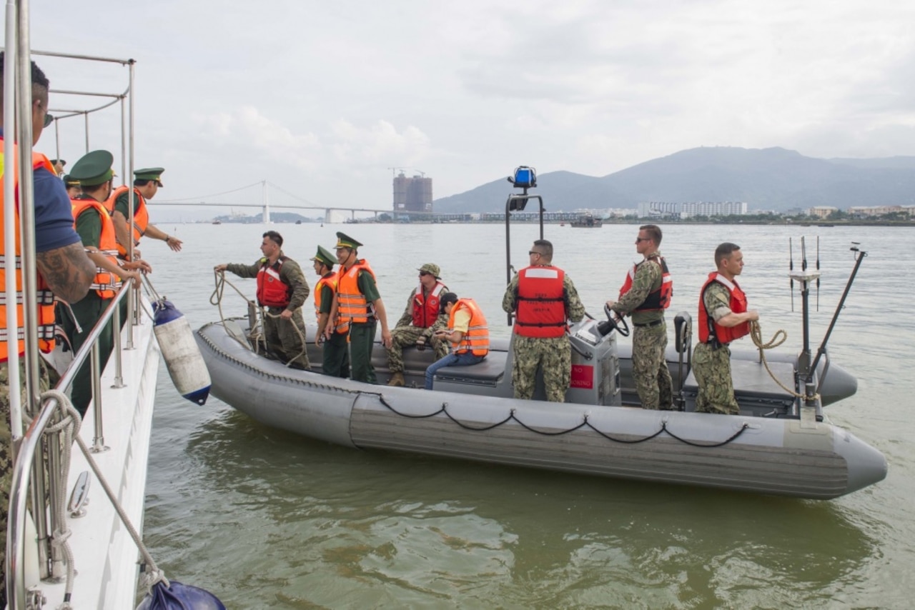 U.S. sailors and Vietnamese border guard personnel prepare to moor a rigid hull inflatable boat to a border guard vessel during a search and rescue and oil spill response field training exercise for Pacific Partnership 2017 in Danang, Vietnam, May 13, 2017. Pacific Partnership is the largest annual multilateral humanitarian assistance and disaster relief preparedness mission conducted in the Indo-Asia-Pacific region and aims to enhance regional coordination in such as medical readiness and preparedness for manmade and natural disasters. Navy photo by Petty Officer 2nd Class Chelsea Troy Milburn