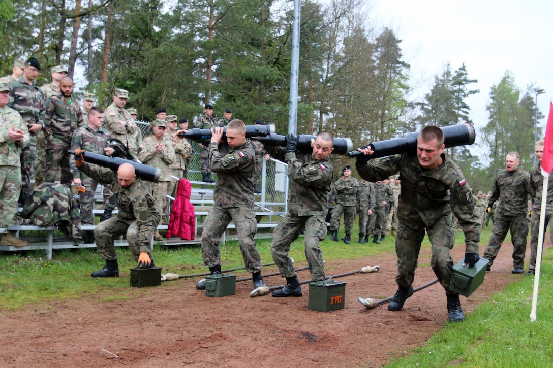 Polish soldiers compete against other nations in a relay race with tank-related objects while U.S. soldiers cheer them on in Grafenwoehr, Germany, May 12, 2017. The Strong Europe Tank Challenge is co-hosted by U.S. Army Europe and the German army, May 7-12, 2017. The competition is designed to project a dynamic presence, foster military partnership, promote interoperability, and provides an environment for sharing tactics, techniques and procedures. Platoons from six NATO and partner nations are in the competition. Army photo by Staff Sgt. Kathleen V. Polanco