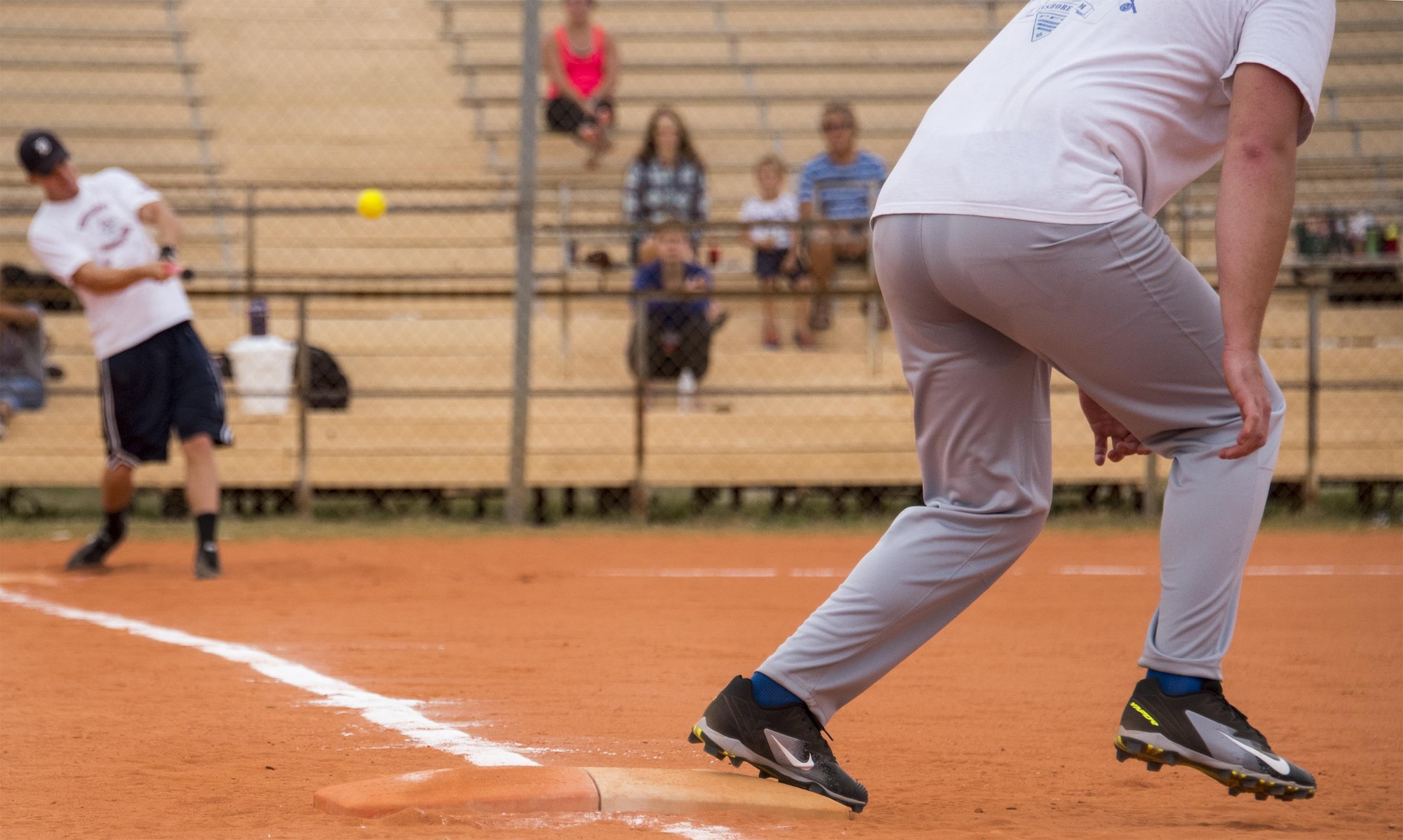 A 33rd Maintenance Group team member hits a line drive as the runner takes off from first base during their team’s intramural softball game against the 96th Communications Squadron team at Eglin Air Force Base, Fla., May 11.  The CS team won easily over the MXG team during the opening week of the intramural softball season.  (U.S. Air Force photo/Samuel King Jr.)