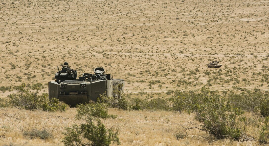 Marines with 3rd Assault Amphibious Battalion in an assault amphibious vehicle and an M1A1 Abrams Main Battle Tank with 1st Tank Battalion provide security during a movement to contact exercise conducted aboard Marine Corps Air Ground Combat Center, Twentynine Palms, Calif., May 4, 2017. Marine Corps Operational Test and Evaluation Activity Office conducted the exercise as part of operational testing used to compare an upgraded AAV to its old variant. (U.S. Marine Corps photo by Cpl. Dave Flores)