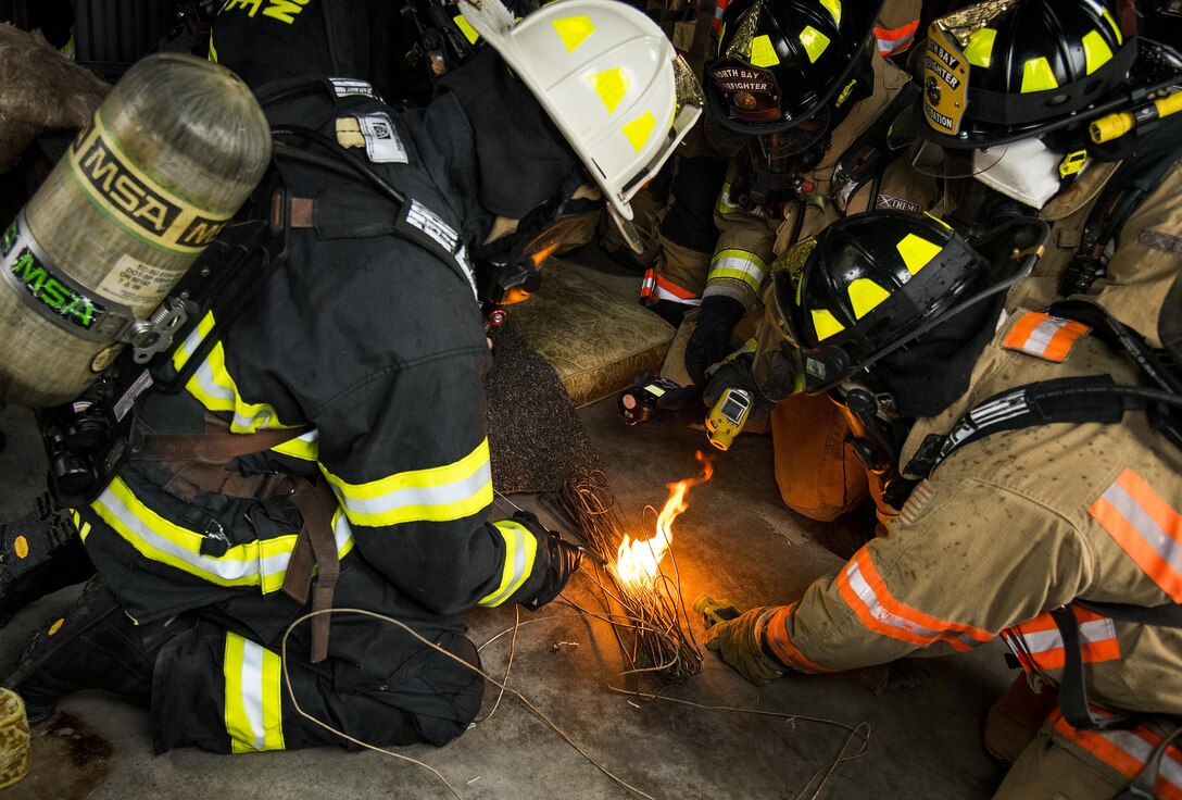 Instructor, Jason Krusen, lights wire on fire as firefighters use a detection device to read the contaminants within the smoke at a “Know Your Smoke” training course held May 12 in Niceville Fla.  More than 10 local fire and rescue agencies attended the lecture and hands-on training including Airmen from Hurlburt Field, Eglin and Tyndall Air Force Bases.  The goal of the course was to highlight the dangers associated with the types of chemicals emitted within smoke during residential and commercial facility fires and how that toxicity has increased over the years.  (U.S. Air Force photo/Samuel King Jr.)