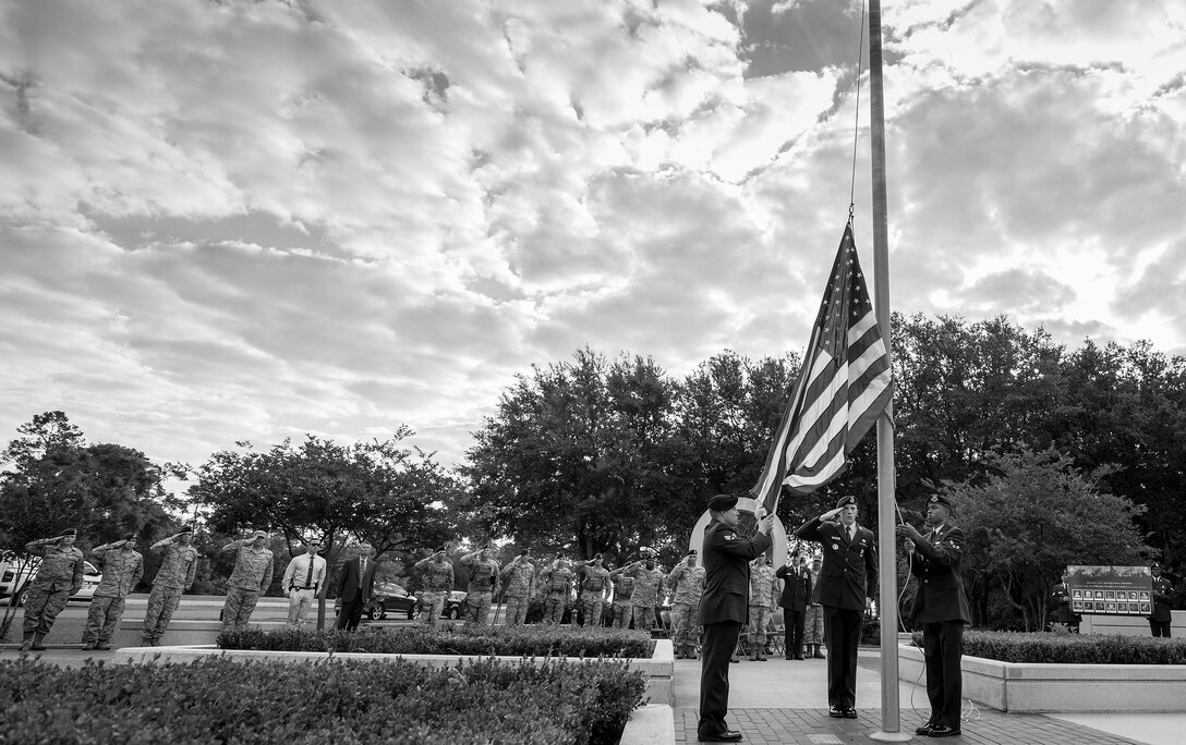 Salutes are rendered as the American Flag is raised at the All Wars Memorial during the opening ceremony of Police Week at Eglin Air Force Base, Fla., May 15.  The ceremony was a gathering of security forces personnel for a formation and reveille ceremony.  Police Week activities will happen throughout the week and will close with security forces Airmen performing a retreat ceremony at Bldg. 1.  (U.S. Air Force photo/Samuel King Jr.)