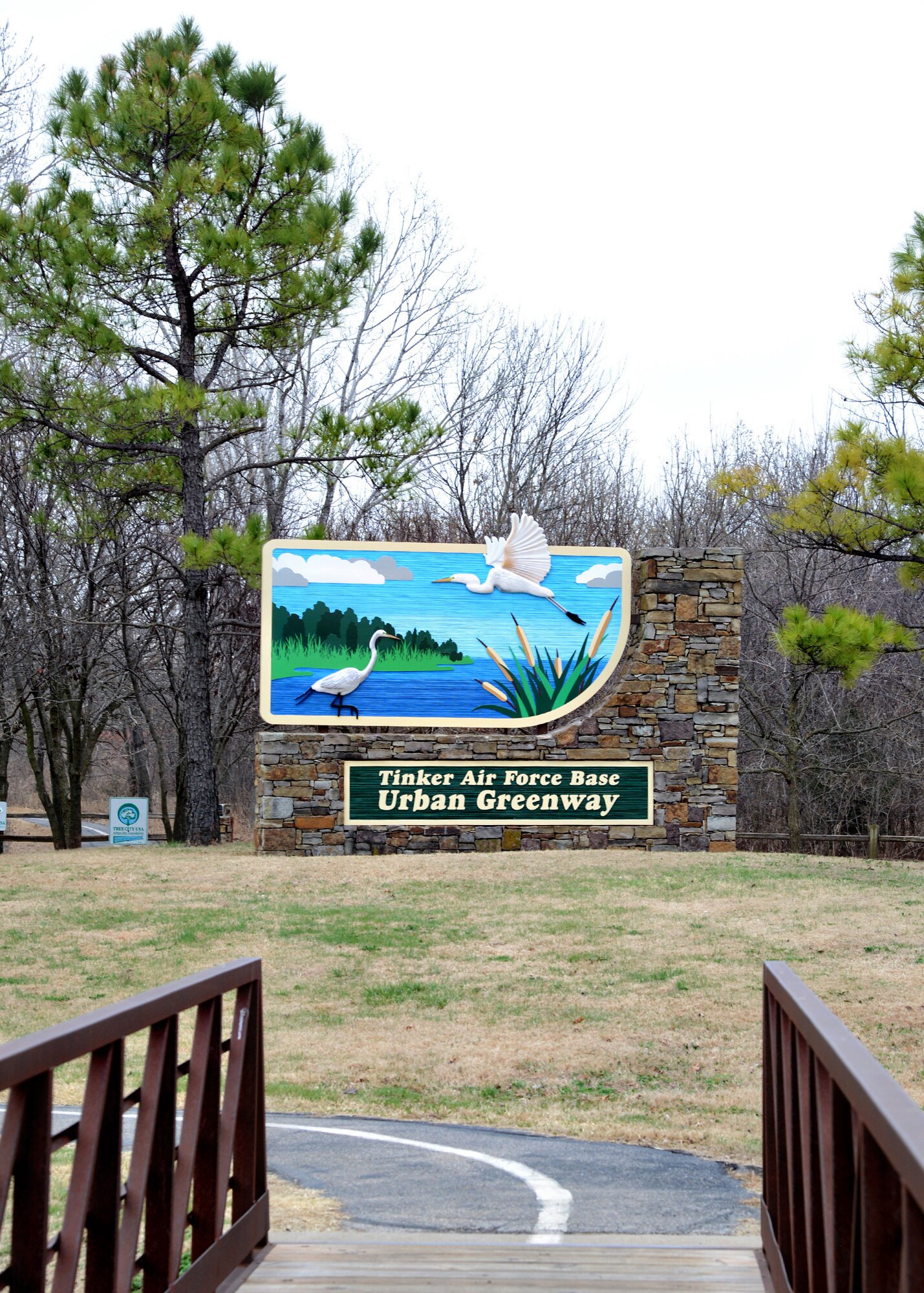 The new Urban Greenway sign stands proud at the entrance to the scenic walking trail, located at Mitchell Ave. and Reserve Rd. The old sign, installed in 1995, had deteriorated beyond repair and the new one was recently installed in January of this year. The 3-dimensional sign was redesigned with a more durable aluminum frame backing (minimum 25 percent recycled content) and the actual sign is made of high-density urethane board with a minimum 15 percent post-consumer content or recovered materials content. The HDU is water and rot-proof and is painted with a durable, commercial-grade automotive-quality topcoat, making it resistant to discoloration, fading, peeling and cracking when exposed to the unpredictable Oklahoma weather. The brilliant colors were intended to invite trail-goers into Tinker’s refreshing green space network. The white birds are Great Egrets, a common large wading bird native to Oklahoma. The sign is expected to last about 40 years with proper care. (Air Force photo by Kelly White)