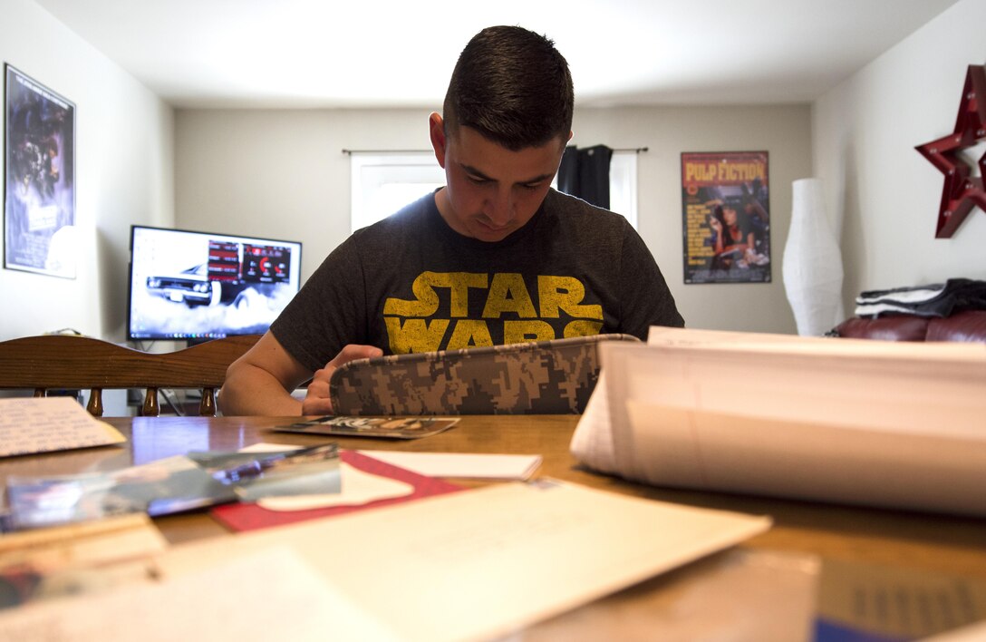 Airman 1st Class Jose Velazquez, U.S. Air Force Honor Guard firing party member, looks through old photos and letters from basic training in his home at Joint Base Anacostia-Bolling, District of Colombia, April 14, 2017. While achieving his goal of joining the military and gaining citizenship during Air Force basic training, Velazquez received mail from family and friends that he still holds onto. (U.S. Air Force photo by Senior Airman Philip Bryant)