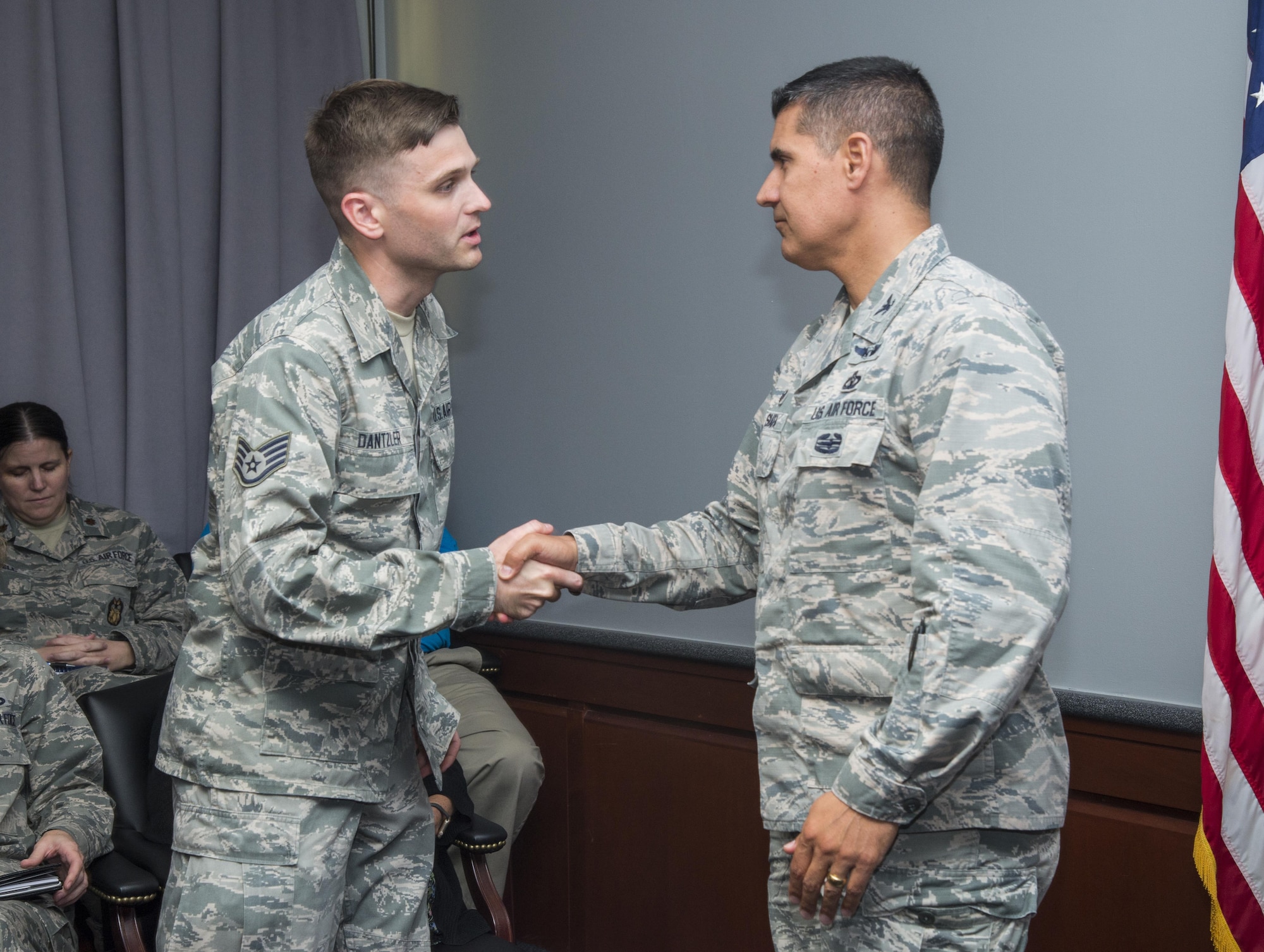 Col. Eric Shafa, 42nd Air Base Wing commander, presents Staff Sgt. Robert Dantzler, 42nd Air Base Wing Public Affairs broadcast journalist, a commander’s coin, May 15, 2017, Maxwell Air Force Base, Ala. Dantzler was awarded first place in the 2016 Defense Media Award’s Video Feature Story category for his video “Our Names on Her Arm.” The video tells the story of the 455th Expeditionary Medical Group’s mission to save the life and leg of a six year old girl who had been shot. Dantzler made the video while deployed at Bagram Airfield, Afghanistan. (U.S. Air Force photo/ Senior Airman Alexa Culbert)