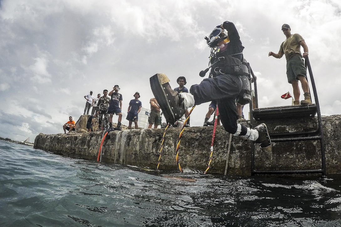 Navy Petty Officer 2nd Class Greg Lewis jumps into the water during an underwater surface-supply dive at Ipil Port in Ormoc City, Philippines, May 12, 2017, as part of exercise Balikatan 2017. The dive training prepared Philippine and U.S. service members to clear debris in ports and open up supply lines. Lewis is a construction electrician assigned to Underwater Construction Team 2. Navy photo by Petty Officer 3rd Class Alfred A. Coffield