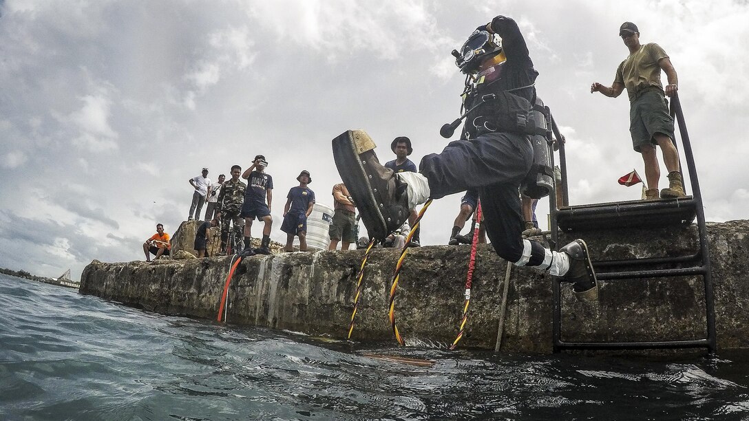 Navy Petty Officer 2nd Class Greg Lewis jumps into the water during an underwater surface-supply dive at Ipil Port in Ormoc City, Philippines, May 12, 2017, as part of exercise Balikatan 2017. The dive training prepared Philippine and U.S. service members to clear debris in ports and open up supply lines. Lewis is a construction electrician assigned to Underwater Construction Team 2. Navy photo by Petty Officer 3rd Class Alfred A. Coffield