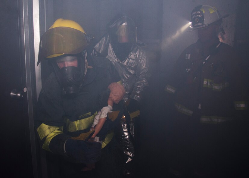 Alex Debowey, a Fire Explorer from Post #9463 in Minot, N.D., rushes a victim to safety during a simulated fire rescue mission at Minot Air Force Base, April 30, 2017. During the mission, the Minot Boy Scouts of America and Fire Explorers forced a door open, stopped a simulated fire, rescued victims and ventilated the area while following basic firefighting procedures. (U.S. Air Force photo/Airman 1st Class Alyssa M. Akers)