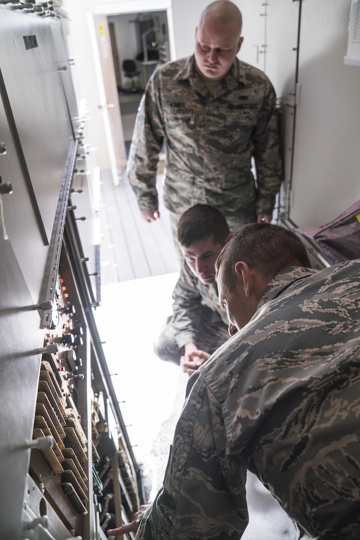 Tech. Sgt. Aaron Steinberg (bottom-right), 266th Range Squadron ground radar technician, shows the inner workings of the Multiple Threat Emitter System to Senior Airman Joshua Vance and Staff Sgt. Zachary Dowd at the Mountain Home Air Force Base Range Complex in Idaho May 9, 2017. Dowd, an Air Force Repair Enhancement Program technician, repaired a $20,000 power supply for the system, saving the Air Force thousands of dollars. (U.S. Air Force photo/Staff Sgt. Samuel Morse)