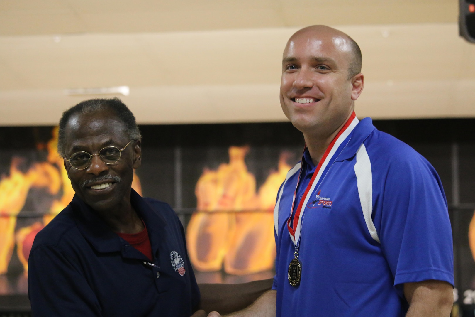Armed Forces Sports Deputy Secretariat Mr. Ken Polk congratulates Air Force Staff Sgt. James McTaggart of Nellis AFB, Nevada for winning the Men's Title at the Armed Forces Bowling Championship hosted at Marine Corps Base Camp Pendleton, California from 5-8 May at the Leatherneck Lanes.