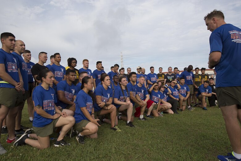 Marines listen as Chief Warrant Officer Clinton Runyon speaks during the Cpl. Medina and Lance Cpl. Hug 2nd Annual Memorial Run May 12 aboard Camp Foster, Okinawa, Japan. On May 12, 2015, Cpl. Sara A. Medina, 23, a combat photographer and Lance Cpl. Jacob A. Hug, 22, a combat videographer assigned to Headquarters and Support Battalion, Marine Corps Installations Pacific-Marine Corps Base Camp Butler, Japan, died while providing humanitarian assistance and disaster relief to remote villages in Nepal during operation Sahayogi Haat. Marines, sailors and members of the military community came from all over Okinawa to honor Medina and Hug.