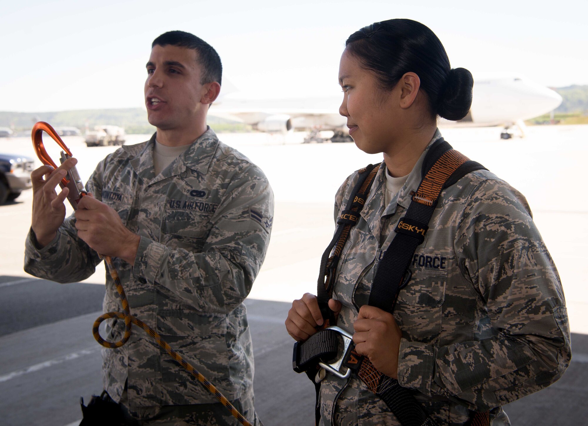Airman 1st Class Hector Montoya, left, 721st Aerial Port Squadron ramp service specialist, uses a volunteer, 2nd Lt. Jenavee Viernes, 721st APS Combat Readiness and Resources Flight commander, to help demonstrate the use of a safety harness on Ramstein Air Base, Germany, May 10, 2017.  Between 2012 and 2016, Air Force personnel were involved in approximately 3,500 falls, not including sports-related falls, which resulted in 13 fatalities. (U.S. Air Force photo by Airman 1st Class Elizabeth Baker)
