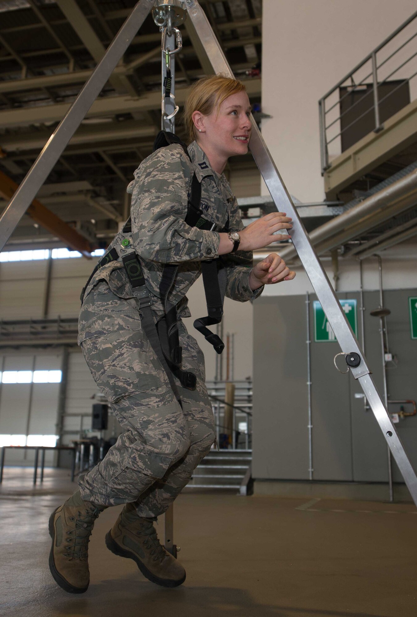 Capt. Teresa Crampton, 721st Aerial Port Squadron Passenger Services Flight commander, hangs in a safety harness during the Occupational Safety and Health Administration's Fall Prevention Stand-Down Week on Ramstein Air Base, Germany, May 10, 2017. The safety stand-down is a voluntary event in which leaders talk directly to personnel about hazards, protective methods and Air Force safety policies. The intention is to reduce the number of injuries and deaths attributed to falls that the Air Force sustains every year. (U.S. Air Force photo by Airman 1st Class Elizabeth Baker)