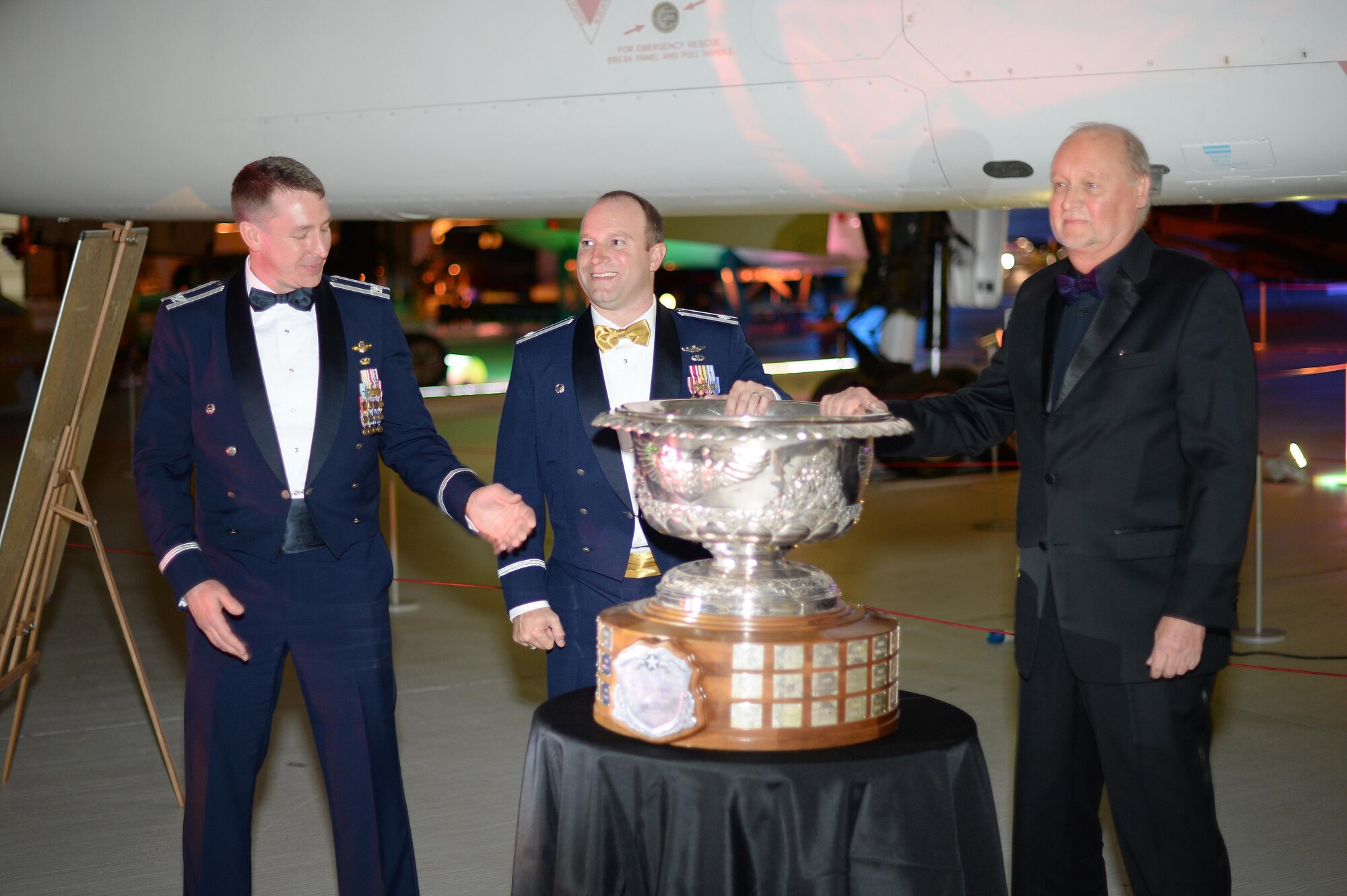 Rick Yuse, President of Raytheon Space and Airborne Systems, right, presents the Raytheon trophy to Lt. Col. Jason Zumwalt, 493rd Fighter Squadron commander and Col. Evan Pettus, 48th Fighter Wing commander, during a celebration at the Duxford Imperial War Museum, England, May 13. The 493rd FS received the trophy as the U.S. Air Force's top fighter squadron. (U.S. Air Force photo by Staff Sgt. Emerson Nuñez)
