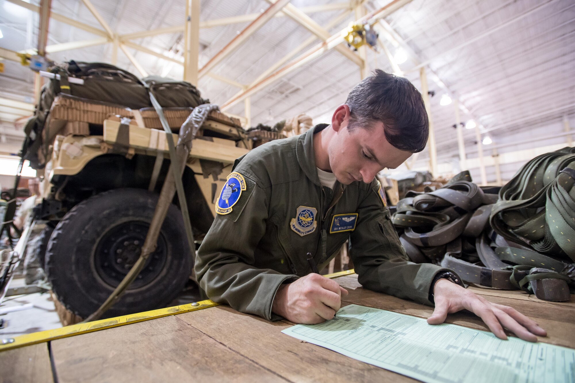 Senior Airman Wesley Zech, a 43d Operations Support Squadron joint airdrop inspector, completes paperwork to clear heavy equipment for airdrop after an inspection at the Army’s Heavy Drop Rigging Facility here April 26. Zech worked with fellow 43d OSS inspectors to ensure more than 200 tons of cargo were ready for airdrop from Air Force C-17s and C-130s flying out of Pope Field during a large package joint training exercise April 26-30. The 43d OSS is part of the Air Force’s 43d Air Mobility Operations Group, which provides 24/7 operational and training mission support for visiting Air Mobility Command aircraft and crews, for the 82nd Airborne Division and other Army units here, and for joint special forces units at Fort Bragg. (U.S. Air Force photo/Marc Barnes)