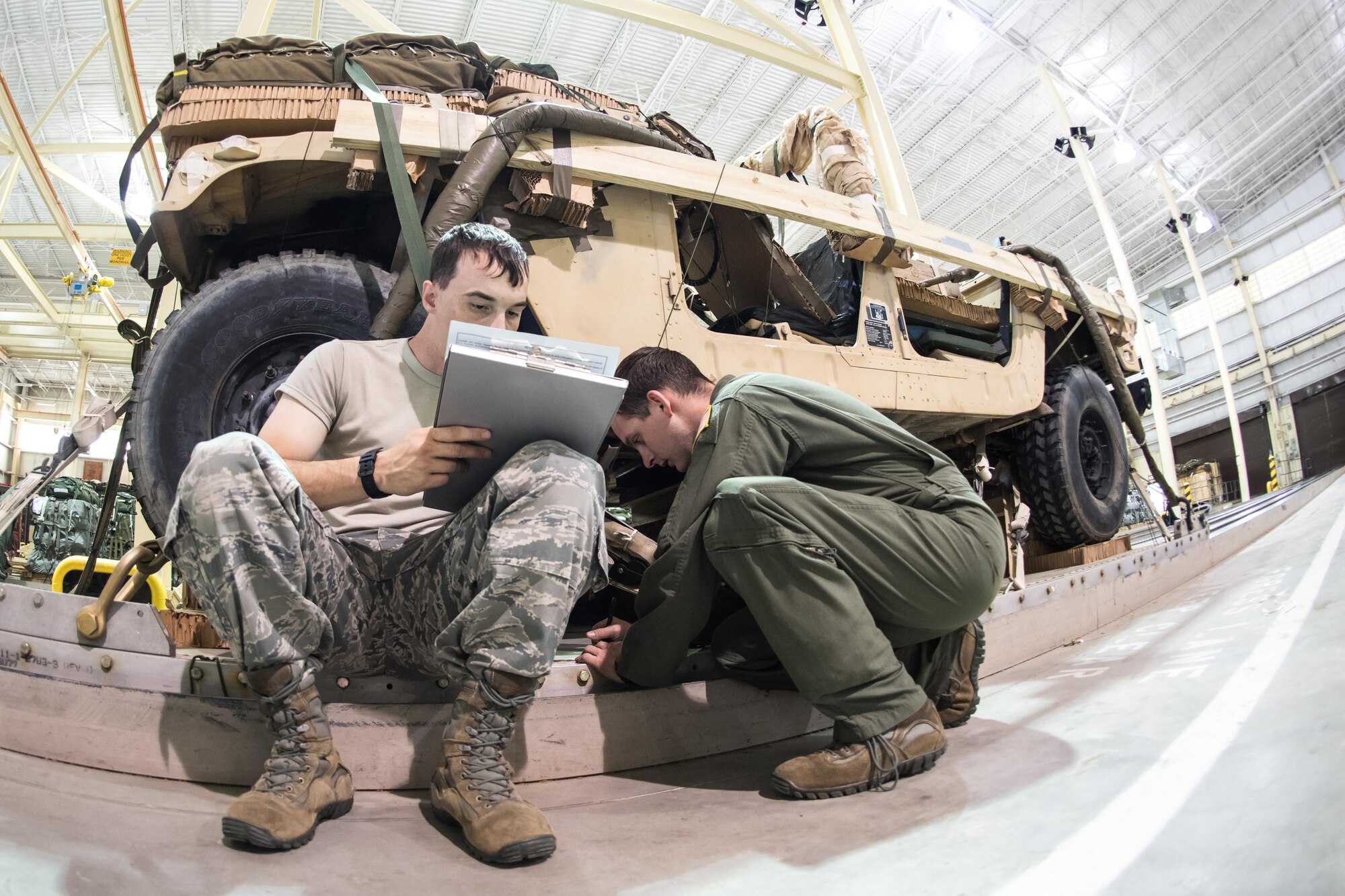 Staff Sgt. Matthew Van Compernolle and Senior Airman Wesley Zech, joint airdrop inspectors in the 43d Operations Support Squadron at Pope Army Airfield, complete paperwork to clear heavy equipment for airdrop after an inspection at the Army's Heavy Drop Rigging Facility here April 26. Van Compernolle and Zech worked with fellow 43d OSS inspectors to ensure more than 200 tons of cargo were ready for airdrop during Large Package Week and Exercise Jade Helm. (U.S. Air Force photo/Marc Barnes)