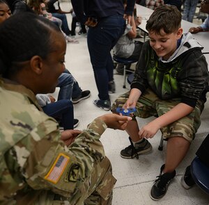 U.S. Army Sgt. 1st Class Shalayne Tucker, 2nd Staff and Faculty Company cargo handling division team chief and instructor writer, interacts with a student during a Lunch Buddies mentor session at Mary L. Passage Middle School in Newport News, Va., May 10, 2017. Soldiers assigned to the company have lunch with and tutor the students as part of the Army’s Adopt-A-School program. (U.S. Air Force photo/Staff Sgt. Teresa J. Cleveland)