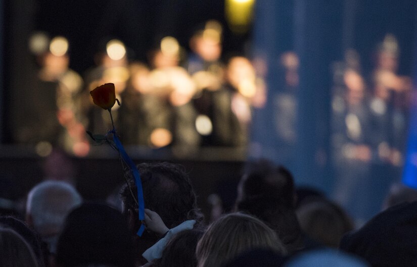 A survivor of a fallen police officer raises a single rose during the 29th Annual Candlelight Vigil honoring fallen police officers from around the country on the National Mall in Washington, D.C., May 13, 2017. Approximately 300 police officers' names were read, engraved into the National Police Memorial. Among those names was Staff Sgt. James D. McNaughton, a U.S. Army Reserve military police who was the first New York City police officer killed in action while deployed to Iraq, Aug. 2, 2005. (U.S. Army Reserve photo by Sgt. Audrey Hayes)