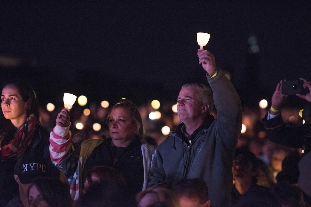 William and Michele McNaughton from, Centereach, New York, raise lit candles as their son's name, Staff Sgt. James D. McNaughton, is read during the 29th Annual Candlelight Vigil on the National Mall in Washington, D.C., May 13, 2017. McNaughton was a U.S. Army Reserve military police who was the first New York City police officer killed in action while deployed to Iraq, Aug. 2, 2005. Approximately 300 police officers' names were read, engraved into the National Police Memorial. (U.S. Army Reserve photo by Sgt. Audrey Hayes)
