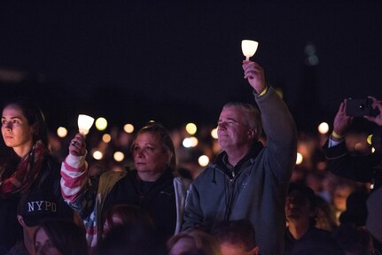 William and Michele McNaughton from, Centereach, New York, raise lit candles as their son's name, Staff Sgt. James D. McNaughton, is read during the 29th Annual Candlelight Vigil on the National Mall in Washington, D.C., May 13, 2017. McNaughton was a U.S. Army Reserve military police who was the first New York City police officer killed in action while deployed to Iraq, Aug. 2, 2005. Approximately 300 police officers' names were read, engraved into the National Police Memorial. (U.S. Army Reserve photo by Sgt. Audrey Hayes)