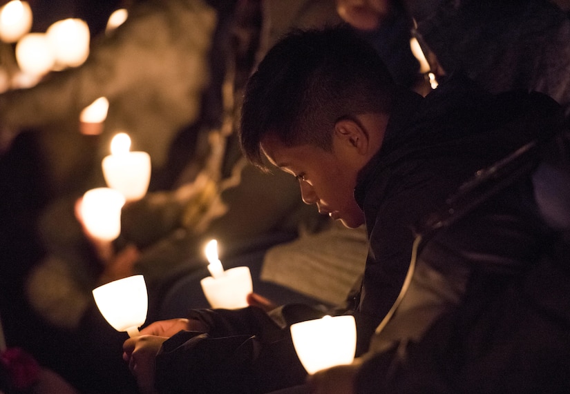 A survivor of a fallen police officer bows his head during the 29th Annual Candlelight Vigil honoring fallen police officers from around the country on the National Mall in Washington, D.C., May 13, 2017. Approximately 300 police officers' names were read, engraved into the National Police Memorial. Among those names was Staff Sgt. James D. McNaughton, a U.S. Army Reserve military police who was the first New York City police officer killed in action while deployed to Iraq, Aug. 2, 2005. (U.S. Army Reserve photo by Sgt. Audrey Hayes)