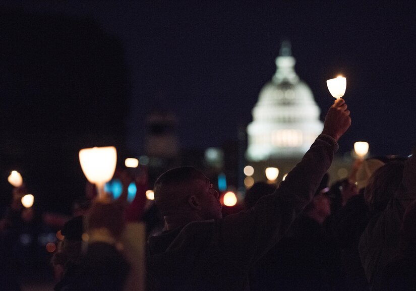 Police officers and family members raise candles during the 29th Annual Candlelight Vigil honoring fallen police officers from around the country on the National Mall in Washington, D.C., May 13, 2017. Approximately 300 police officers' names were read, engraved into the National Police Memorial. Among those names was Staff Sgt. James D. McNaughton, a U.S. Army Reserve military police who was the first New York City police officer killed in action while deployed to Iraq, Aug. 2, 2005. (U.S. Army Reserve photo by Sgt. Audrey Hayes)