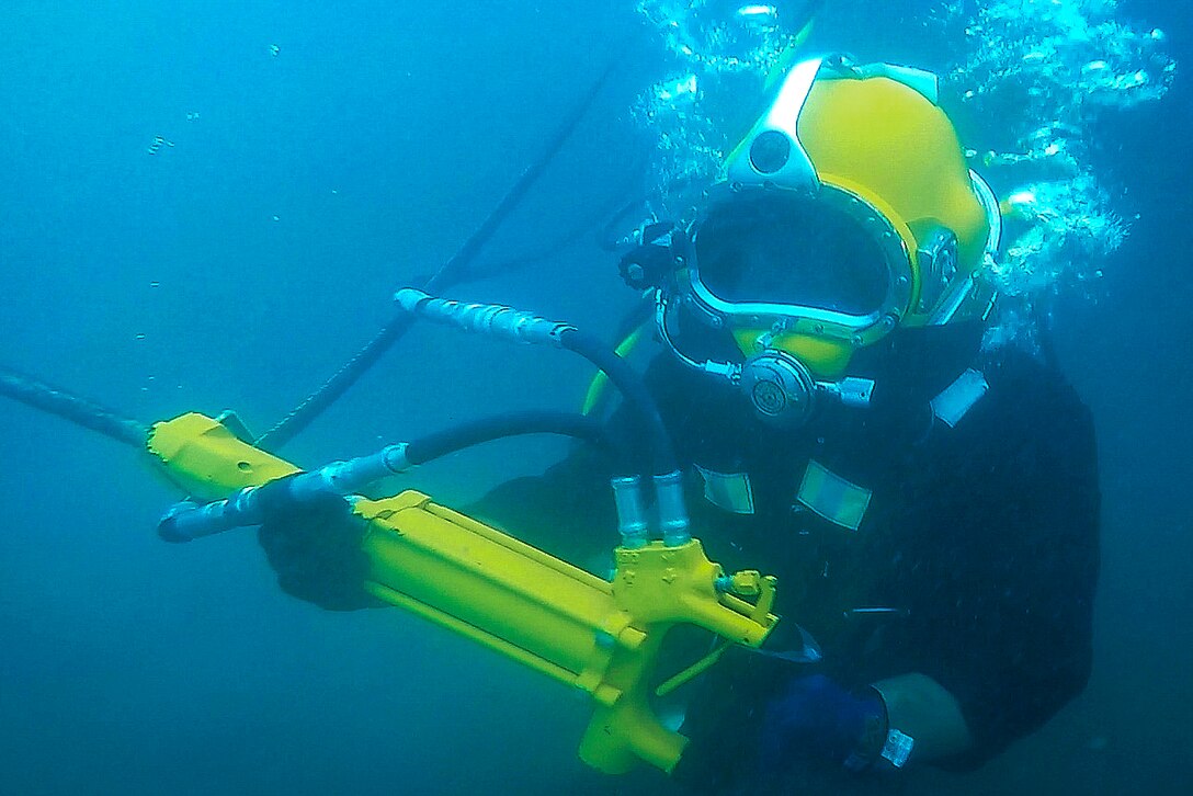 Navy Petty Officer 2nd Class Greg Lewis carries a hydraulic chipping hammer during an underwater surface-supply dive as part of exercise Balikatan 2017 at Ipil Port in Ormoc City, Philippines, May 12, 2017. Lewis is a construction electrician assigned to Underwater Construction Team 2. Navy photo by Petty Officer 3rd Class Alfred A. Coffield
