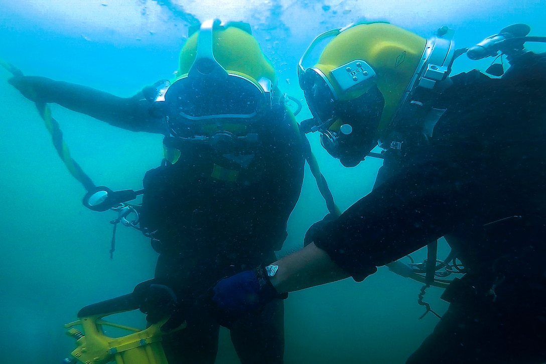 Navy Petty Officer 2nd Class Greg Lewis, right, shows a Philippine sailor the operating procedures of a hydraulic chipping hammer during an underwater surface-supply dive as part of exercise Balikatan 2017 at Ipil Port in Ormoc City, Philippines, May 12, 2017. Lewis is a construction electrician assigned to Underwater Construction Team 2. Navy photo by Petty Officer 3rd Class Alfred A. Coffield