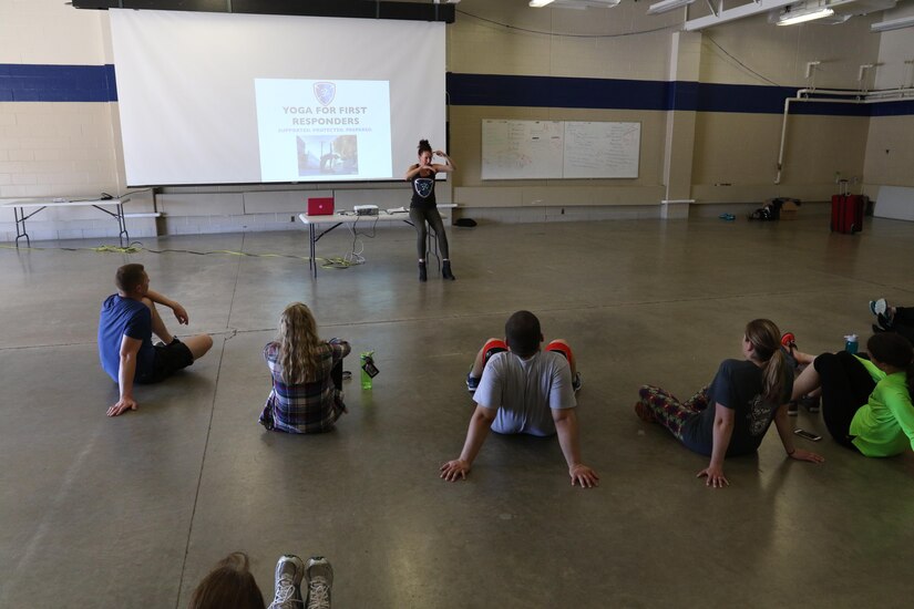 Olivia Kvitne, top, provides a lecture about the history and benefits of Yoga to members of the 103rd Sustainment Command (Expeditionary) on May 12, 2017 at Fort Des Moines, Iowa.  Kvitne is founder of Yoga for First Responders which focuses on providing Yoga as a tool to relieve stress for veterans and those who have experienced post-traumatic stress disorder.  (Released/U.S. Army photo by Capt. Charles An)