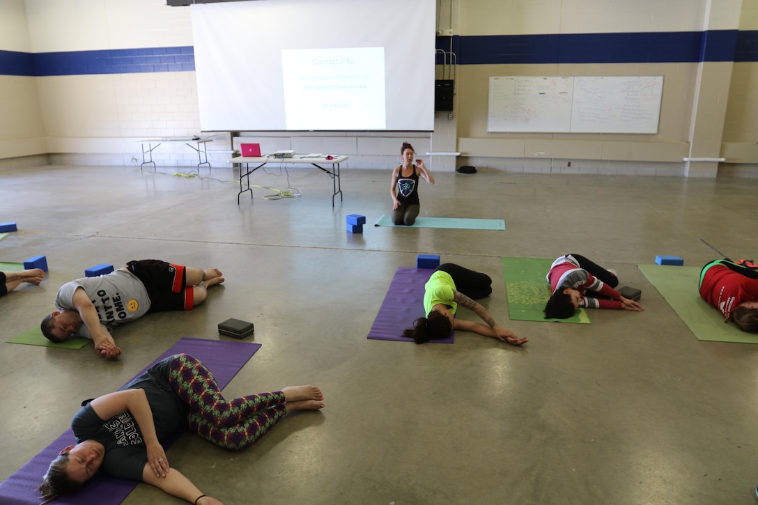 Olivia Kvitne, top, provides a Yoga instructions to members of the 103rd Sustainment Command (Expeditionary) on May 12, 2017 at Fort Des Moines, Iowa.  Kvitne is founder of Yoga for First Responders which focuses on providing Yoga as a tool to relieve stress for veterans and those who have experienced post-traumatic stress disorder.  (Released/U.S. Army photo by Capt. Charles An)