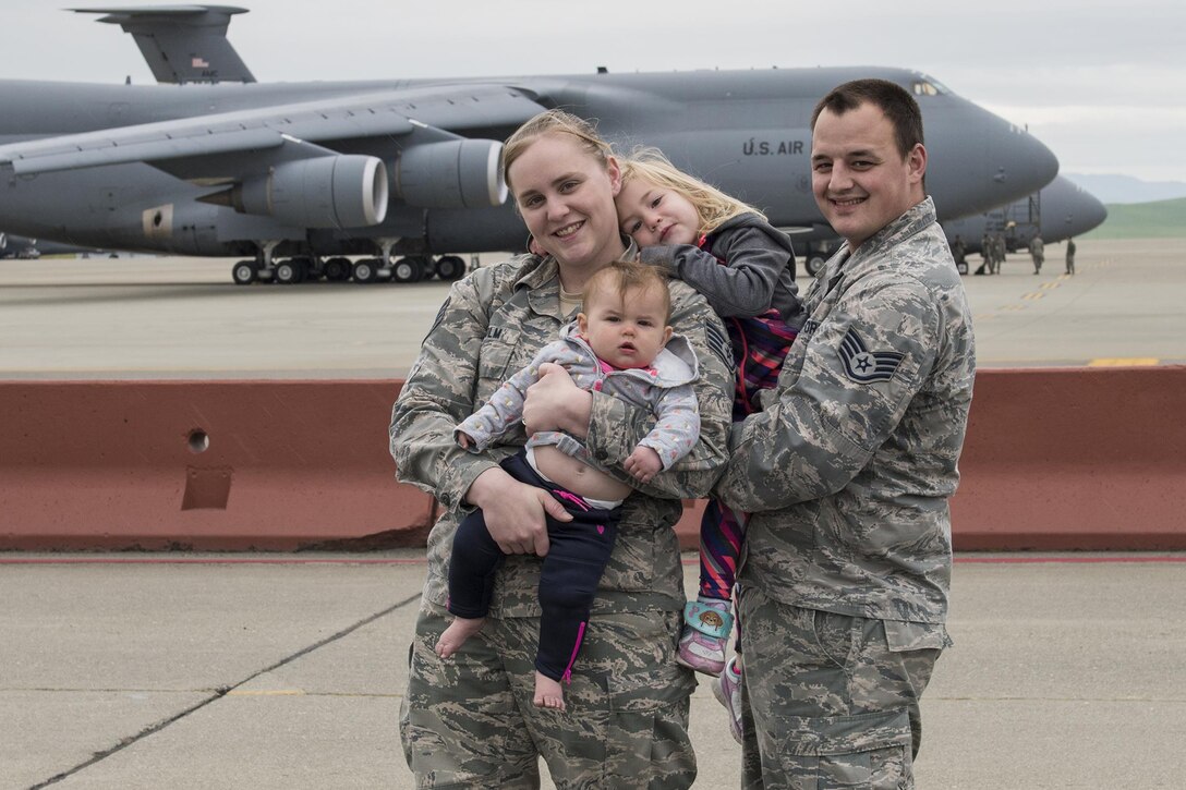 Air Force Staff Sgts. Kyle Leidholm of the 60th Aircraft Maintenance Squadron and Nicole Leidholm of 60th Air Mobility Wing Public Affairs pose for a family portrait at Travis Air Force Base, Calif., April 6, 2017. In addition to the challenges they face as individual service members, the couple must also contend with issues unique to dual-military couples. Air Force photo by Heide Couch