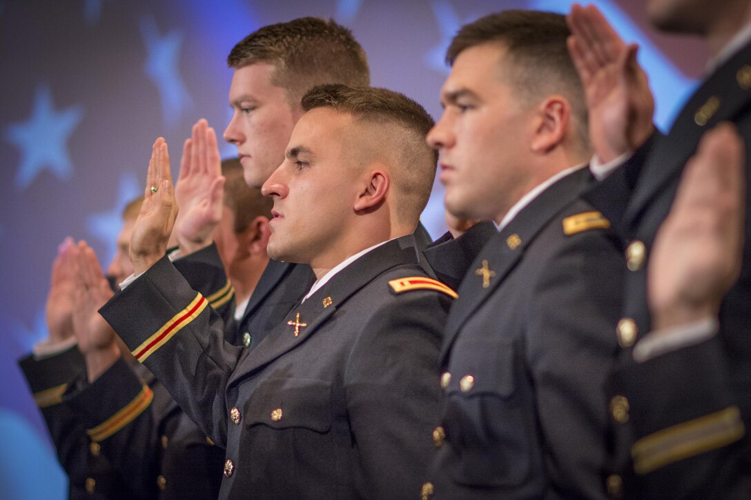 Fifteen very-soon-to-be U.S. Army second lieutenants take the oath of office during their commissioning ceremony at Clemson University, May 10, 2107. Allen Robertson, in the middle, would propose to his girlfriend and become engaged less than an hour later. (U.S. Army Reserve photo by Staff Sgt. Ken Scar)