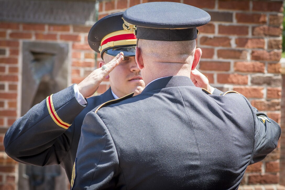 Brand new U.S. Army 2nd Lt. Allen Robertson (left), of Mooresville, N.C., receives his first salute as an officer from Master Sgt. Shane Werst, senior military leadership instructor for Clemson University’s Reserve Officers’ Training Corps program, during a Silver Dollar Ceremony, May 10, 2017.  (U.S. Army Reserve photo by Staff Sgt. Ken Scar)
