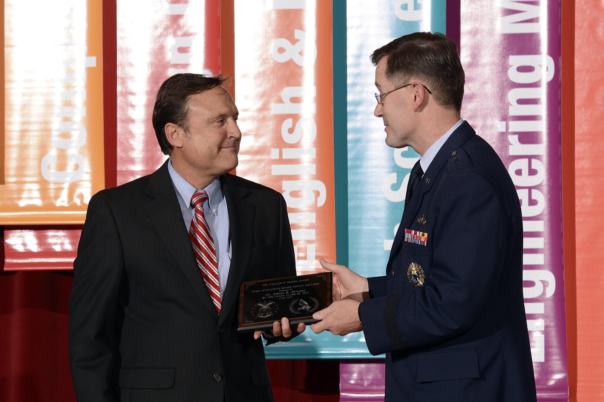 Aaron Byerley receives the Heiser Award from Dean of Faculty Brig. Gen. Andrew Armacost, May 5, 2017 at the U.S. Air Force Academy. Byerley is an engineering professor at the the Academy. The Heiser award is named after Professor Emeritus Dr. William H. Heiser and given to faculty members who contribute to cadets' development. (U.S. Air Force photo/Darcie Ibidapo)
