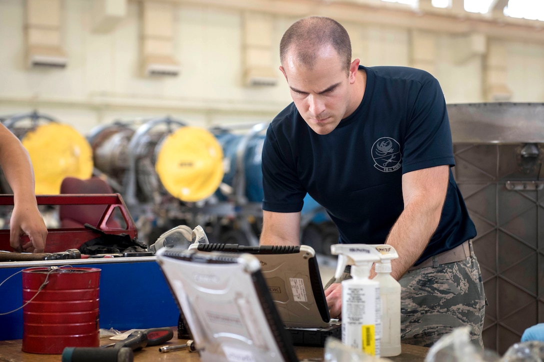 Air Force Airman 1st Class Jon Barrett refers to his technical orders before he services an F-15 Eagle aircraft engine at Kadena Air Base, Japan, May 12, 2017. Barrett is an aerospace propulsion technician assigned to the 18th Component Maintenance Squadron. The technical orders list detailed tasks that must be completed by technicians and inspectors to ensure the aircraft will function properly. Air Force photo by Senior Airman John Linzmeier
