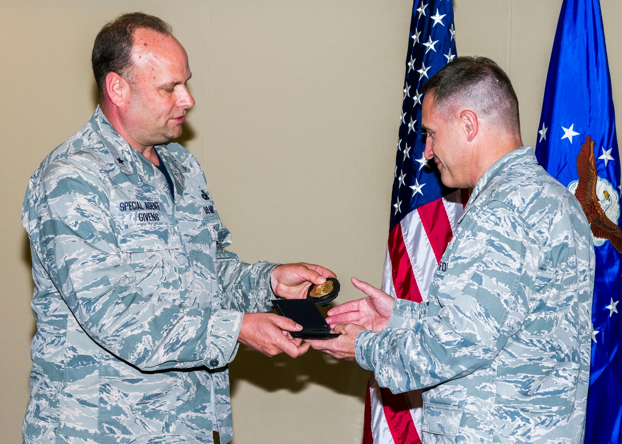 Air Force Office of Special Investigations Commander, Brig. Gen. Keith M. Givens welcomes his successor, Col. Kirk. B. Stabler by passing AFOSI Badge and Credential 1 to him May 16, 2017. Col. Stabler will lead the 69-year old law enforcement organization beginning May 18, 2017. (U.S. Air Force photo/Michael Hastings)