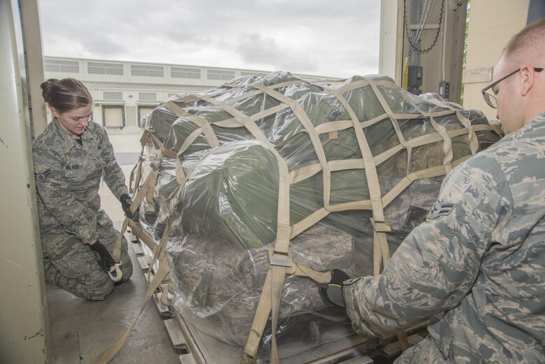 Airman 1st Class Gentry Walker and A1C Karsten Sorebo, both 436th Aerial Port Squadron passenger terminal service agents, secure a pallet of gear during the exercise personal deployment function line May 12, 2017, on Dover Air Force Base, Del. Although an exercise, the bags where still processed as if they were going to be put on an aircraft, bagged and strapped to the pallet. (U.S. Air Force photo by Staff Sgt. Jared Duhon)
