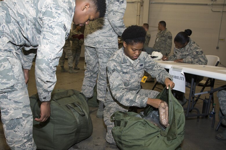 Airman 1st Class Noele Noubi, 436th Logistics Readiness Squadron storage and issue, helps Airman 1st Class Dimitrious Russell, 436th LRS petroleum, oil and lubricants fuels operator, during the exercise personal deployment function line May 12, 2017, on Dover Air Force Base, Del. Although an exercise, the people participating were deployers and were able to complete checklists and get mission related gear. (U.S. Air Force photo by Staff Sgt. Jared Duhon)