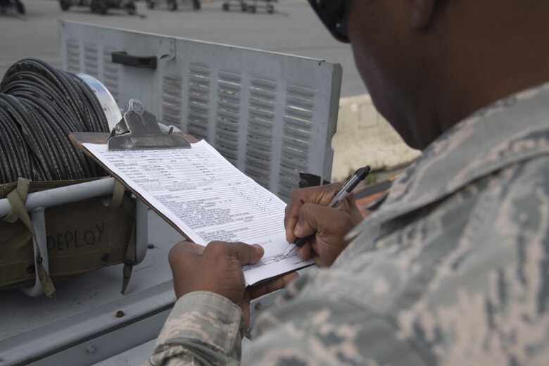 Tech. Sgt. Ryan Stamps, 436th Aerial Port Squadron fixed wing joint inspector, signs an equipment inspection form during the exercise personal deployment function line May 12, 2017, on Dover Air Force Base, Del. All equipment that is going to be shipped overseas has to be measured and weighed multiple times by different people to ensure the most accurate information is given to have the aircraft load balanced. (U.S. Air Force photo by Staff Sgt. Jared Duhon)