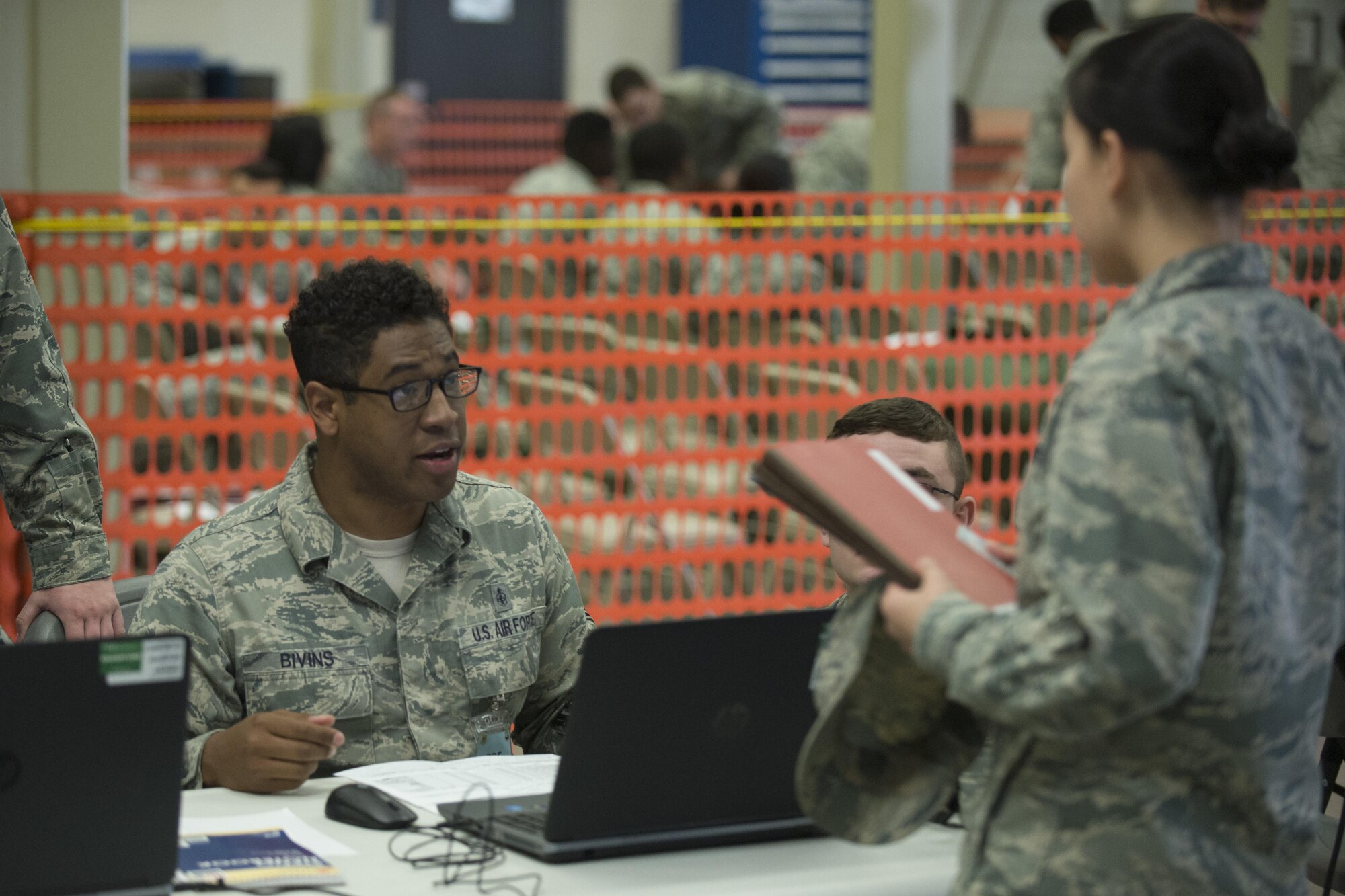 Staff Sgt. Antonio Bivins, 436th Aerospace Medicine Squadron NCO in charge of deployment medicine, talks with 2nd Lt. Jenny Aroune, 436th Contracting Squadron contract specialist, during the exercise personal deployment function line May 12, 2017, on Dover Air Force Base, Del. Medical was able to provide shots and sign checklists off for deployers. (U.S. Air Force photo by Staff Sgt. Jared Duhon)